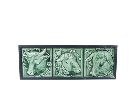 Charming framed panel featuring three green Majolica tiles depicting finely detailed farm animal heads: a bull, a sheep, and 