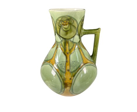 A remarkable example of Minton Secessionist pottery, this pitcher displays vibrant hues of green, yellow, and orange with a s