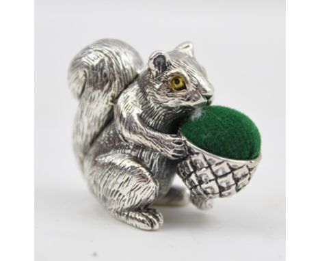 A SILVER PIN CUSHION modelled as a seated squirrel with acorn, 30mm x 25mm, marked "Sterling" to base 