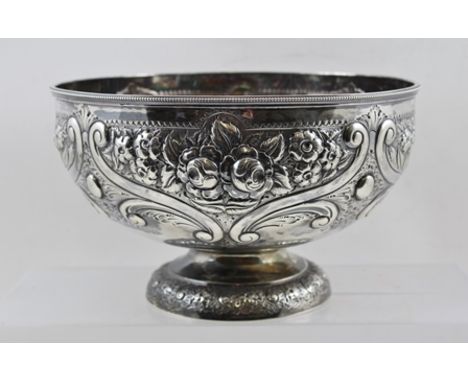 HENRY WILKINSON AND CO. A LATE VICTORIAN SILVER ROSE BOWL having floral embossed decoration, raised on a circular platform fo