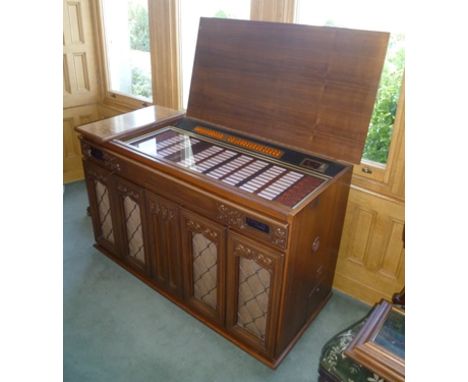  A "WURLITZER" CABARET 160 CABINET JUKE BOX, having mahogany veneer with Jacobean style front carving, fitted four carved sur