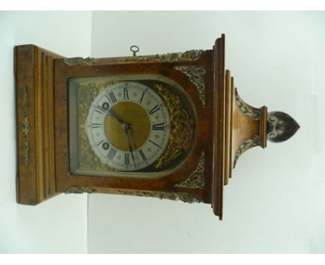 A GEORGIAN DESIGN MANTEL CLOCK, having burr maple veneered case with decorative brass mounts, arched top face with cast spand