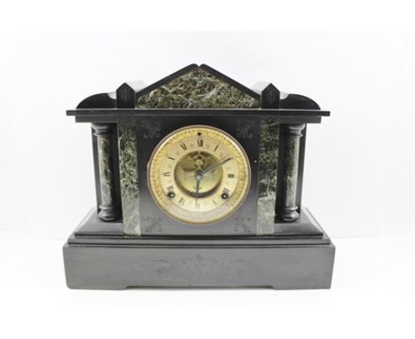 A LATE VICTORIAN BLACK SLATE MANTEL CLOCK of architectural design, the gilded dial with Roman numerals and outside display co
