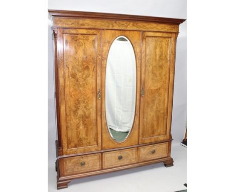 AN EDWARDIAN WALNUT VENEER WARDROBE by SHAPLAND &amp; PETTER of Barnstaple, fitted central oval plate dressing mirror, moulde