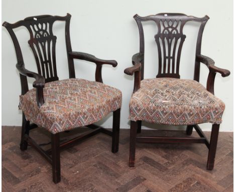 Pair of Georgian Chippendale design, mahogany elbow chairs with leaf carved patterned arms and upholstered seats, standing on