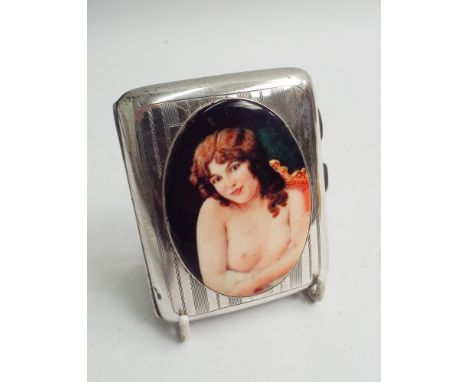 Silver cigarette case with engine turned decoration and applied oval enamel plaque decorated with nude female figure, 8 cms l