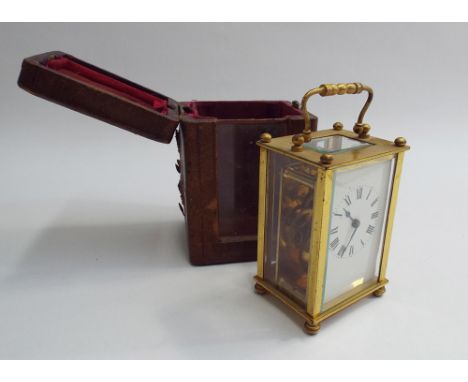Brass and glass cased carriage clock 14cm high (with handle), complete with leather travelling case 
