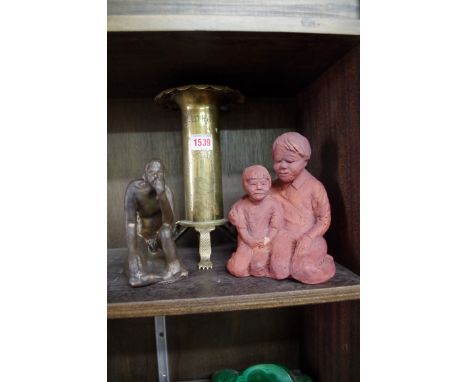 A World War I brass trench art candlestick; together with two pottery figures. 