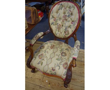 A Victorian carved walnut and button upholstered occasional open arm chair.&nbsp; 