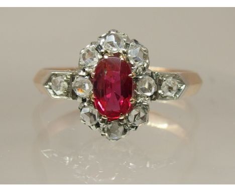 A Victorian ruby and diamond ring set with an oval cut ruby and rose cut diamonds, set in yellow and white metal, the interio