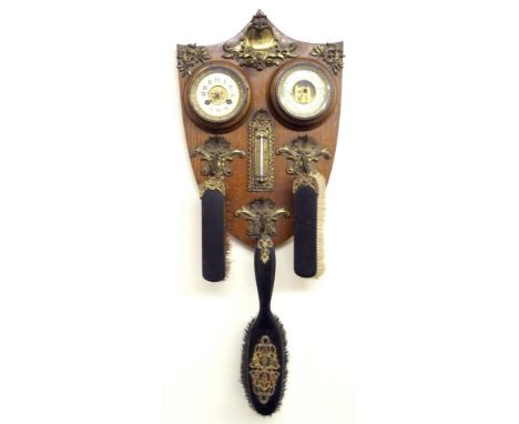 A Victorian oak wall barometer and clock the shield-form backplate mounted with clock, barometer and thermometer, three gilt 