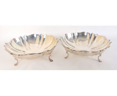 A pair of silver bowls by William Hutton & Sons, London 1908, of shallow circular form with scalloped rim and fluted body in 