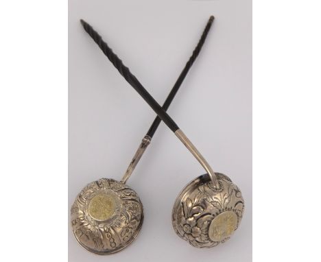 A George II toddy ladle the unmarked bowl with embossed foliate decoration and set with a coin, with whalebone handle, 33cm l