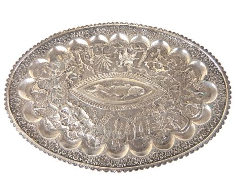 An Eastern white metal tray no visible marks, of oval shape with floral border, profusely embossed with hunting scenes, anima