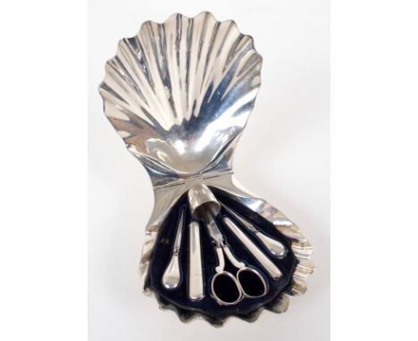 A white metal sewing set in fitted shell shaped case, on three shell feet, by Henry Wilkinson, London 1870, comprising; a pai