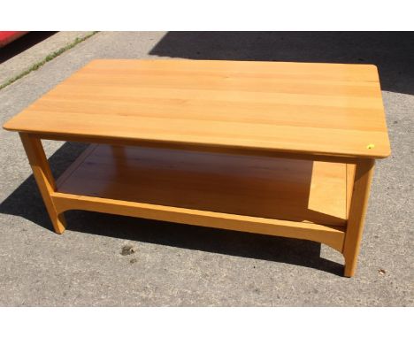 An Ercol light oak two-tier coffee table, 43" wide x 24" deep x 18" high 