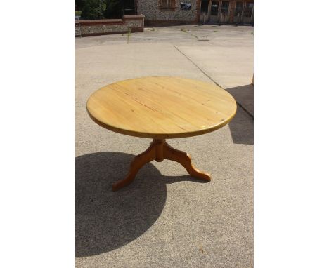 A pine circular dining table, on turned column and tripod splay support, and a set of four spindle back dining chairs with pa