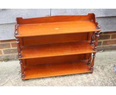 A late 19th century mahogany ledge back three-tier open wall shelf with turned pilasters, 28" wide x 7" deep x 22 1/2" high 