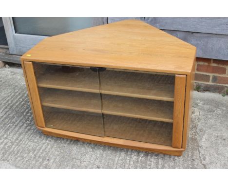 An Ercol elm corner television stand, fitted two shelves and glass doors, 36" wideCondition:General wear and tear and nibbles