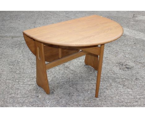 An Ercol ash oval drop leaf dining table, on gateleg supports, 42" x 48" x 28 1/2" high Condition: Minor surface marks and on