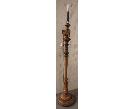 A polished as walnut and carved standard lamp, on circular base 