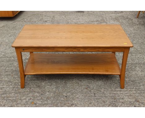 An Ercol ash two-tier coffee table, on shaped supports, 36 1/2" wide x 19 3/4" deep x 16 3/4" high 