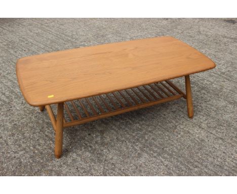 An Ercol elm low coffee table with spindle under-tier, on splay supports, 41" wide x 19" deep x 14 1/2" highCondition:The tab