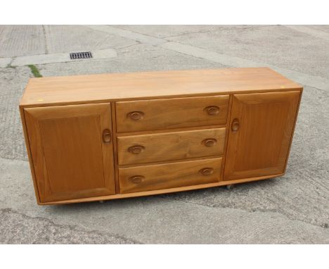 An Ercol 455 elm sideboard, fitted three centre drawers and flanking cupboards, 61 1/2" wide x 18" deep x 26 1/2" highConditi