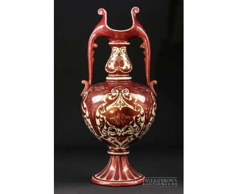 A Craven & Dunnill ruby lustre two handled vase, bottle form with stylised leaf handles, decorated with floral motifs, painte