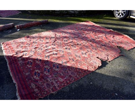 (HP) An Eastern carpet, having repeated Gul design to central field with geometric borders on a red ground, 329 x 220cm. 