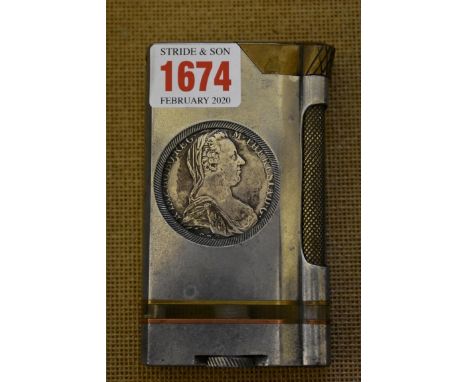 An unusual Trench Art style aluminium and brass table lighter, inset with two Maria Theresa coins, 11cm high.&nbsp; 