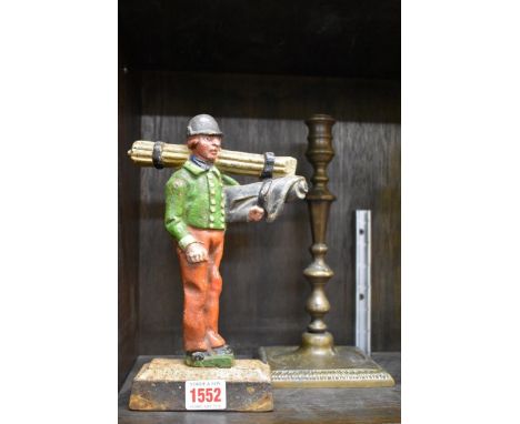 A polychrome painted cast iron figural doorstop,&nbsp;24cm high; together with an antique brass candlestick, 26cm high.&nbsp;