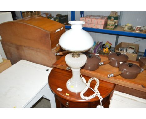 A converted oil lamp with milk glass shade