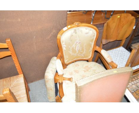 A floral upholstered armchair with tapestry back