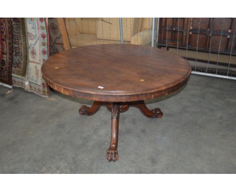 A 19th Century mahogany circular top table raised on tripod base with paw feet