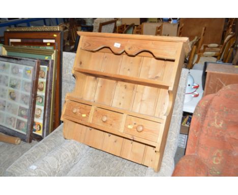 A hanging pine shelf fitted three drawers