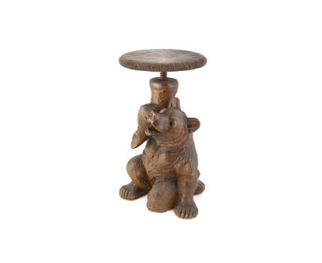 A BLACK FOREST ADJUSTABLE STOOL, 19th century, carved in the form of a bear holding aloft a tree branch with circular platfor