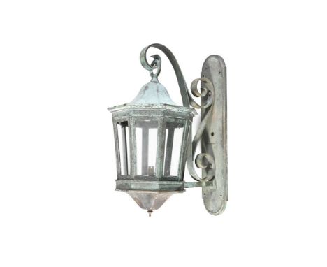 A LARGE BRONZE OCTAGONAL WALL LANTERN,  fitted with bevelled glass plates, and suspended from a wrought iron scroll and backp