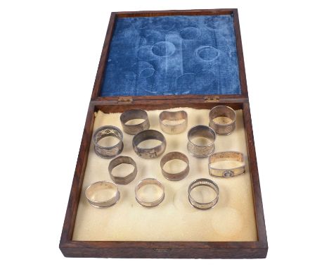 Eleven silver napkin rings, one with enamelled mount, and one white metal and niello napkin ring, Egyptian scene, gross weigh