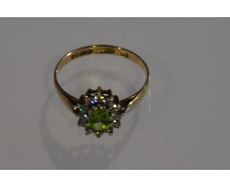 A pale green citrine and diamond dress ring claw set in a 9ct yellow gold band