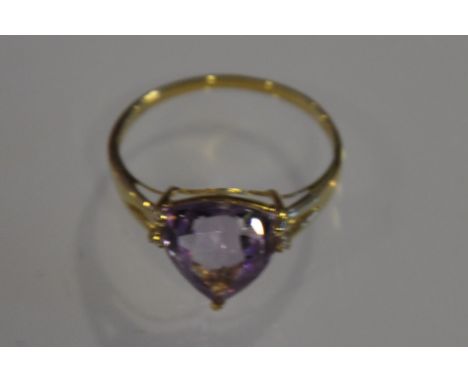 An amethyst and diamond dress ring, the trillion cut stone claw set in a 9ct yellow gold band