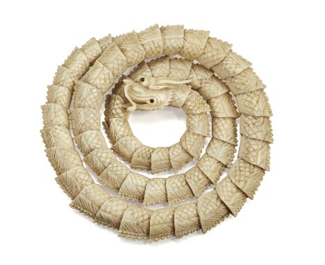 A CHINESE IVORY BANGLE, 19TH CENTURY, in the form of a coiled dragon.