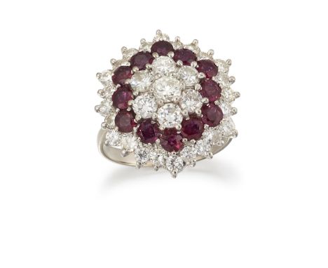 A RUBY AND DIAMOND CLUSTER RING, the hexagonal cluster set to centre with diamonds and a single row of rubies around the midd