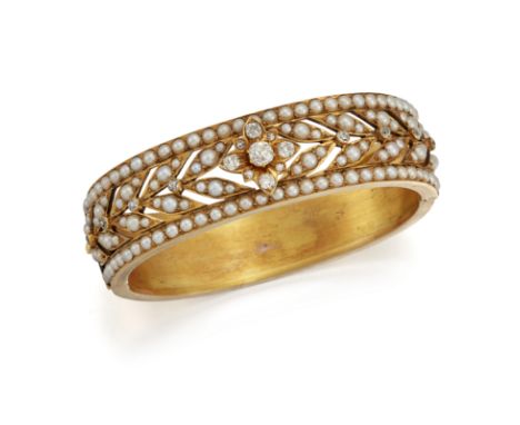 A FRENCH DIAMOND AND PEARL BANGLE, the hinged bangle set with a central old mine cut diamond and surrounded by smaller diamon