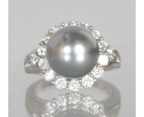 A BLACK PEARL AND BRILLIANT SET RING in silver.