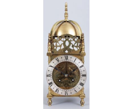 A BRASS LANTERN CLOCK with eight-day movement, bell and silvered dial. 12ins high.