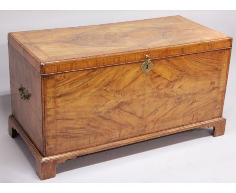 A GOOD 18TH CENTURY WALNUT CHEST with crossbanded rising top, brass carrying handles to the sides and supported on bracket fe