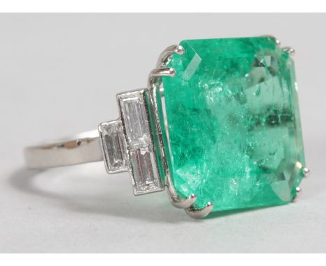 A LARGE NATURAL COLOMBIAN  SQUARE STEP CUT EMERALD RING, 12.60CT, set with six baguette cut diamonds in platinum. Sold with G