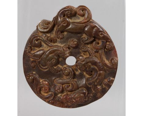 A LARGE CHINESE CIRCULAR JADE PENDANT carved with fish and dragons. 3ins diameter.