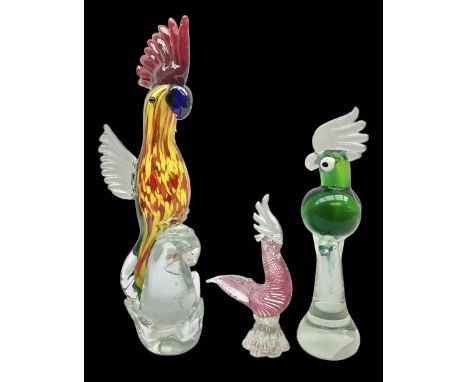 Three Murano style glass cockatoo parrots, the first with mottled yellow, red and orange body, clear outstretched wings, dark